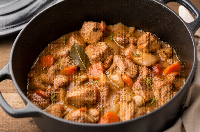 Sauté de porc mijoté en sauce dans une cocotte en fonte avec légumes