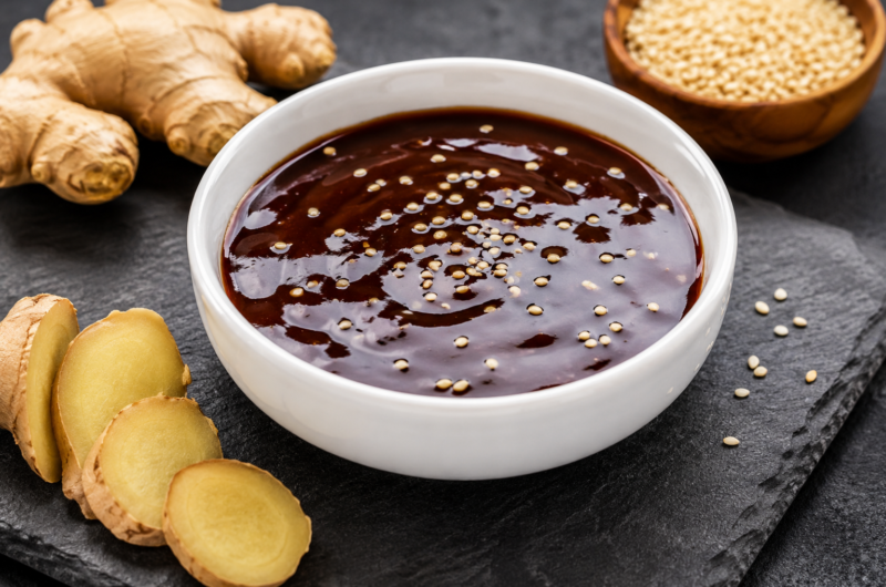 Sauce teriyaki brillante dans un bol blanc avec des graines de sésame et du gingembre